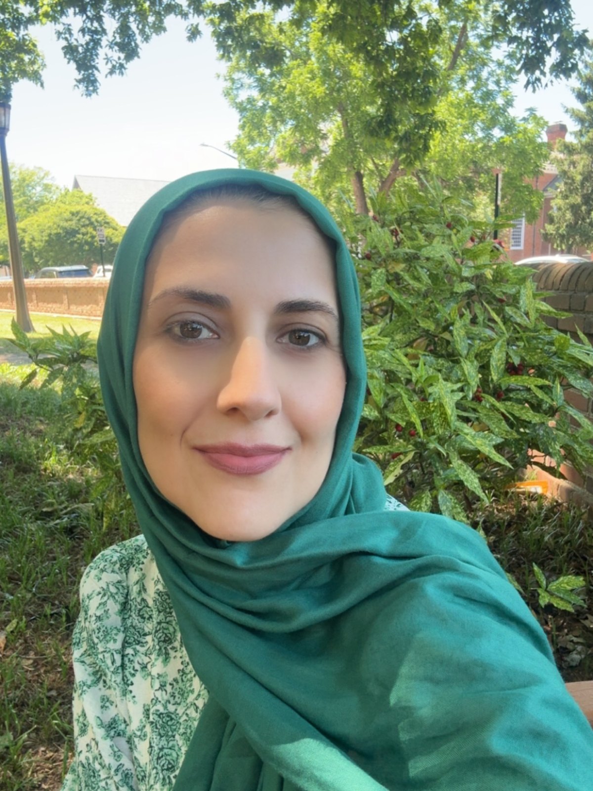 Mejegan, a menopause coach, outdoors in a green hijab